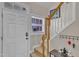 Entry way with a white door, stairway and black coat rack. Wood and carpet flooring at 2043 White Pond Ct, Apex, NC 27523