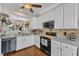 Bright kitchen with white cabinetry, stainless steel appliances, and hardwood floors throughout at 2043 White Pond Ct, Apex, NC 27523