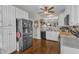 Bright kitchen boasts stainless steel refrigerator, white cabinets, and hardwood floors for a modern and functional cooking area at 2043 White Pond Ct, Apex, NC 27523