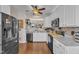 Modern kitchen with white cabinets, black appliances, and hardwood floors. Ceiling fan overhead at 2043 White Pond Ct, Apex, NC 27523