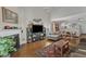 Spacious living room with hardwood floors, fireplace, television, and seamless access to the kitchen and dining areas at 2043 White Pond Ct, Apex, NC 27523