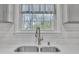 Stainless steel faucet with double sink and a view of the backyard through a kitchen window at 215 Longview Dr, Smithfield, NC 27577