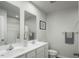 Bright bathroom featuring dual sinks, white cabinetry, and a framed mirror, creating a clean and functional space at 221 N Coral Bells Way, Four Oaks, NC 27524