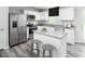Well-lit kitchen featuring white cabinets, stainless steel appliances, and a functional center island with bar stools at 221 N Coral Bells Way, Four Oaks, NC 27524