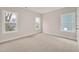 Empty bedroom with carpet flooring, three windows, and neutral paint at 2212 Edwin Ave # A, Durham, NC 27705
