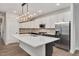Bright, open kitchen featuring a large island, modern lighting, and stainless steel refrigerator at 2212 Edwin Ave # A, Durham, NC 27705