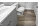 Bathroom with modern fixtures, grey vanity, toilet, and wood-look flooring at 23 Round Spring Ln, Durham, NC 27712