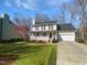 Charming two-story home with a welcoming front porch, well-manicured lawn, and an attached two-car garage at 23 Round Spring Ln, Durham, NC 27712