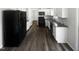 Modern kitchen with white cabinets, granite countertops, stainless steel appliances, and hardwood flooring at 23 Round Spring Ln, Durham, NC 27712
