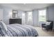 Bright bedroom with large windows, a grey dresser and a sitting chair at 231 N Coral Bells Way, Four Oaks, NC 27524