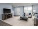Spacious living room with plush carpeting, neutral-toned furniture, modern décor and abundant natural light at 231 N Coral Bells Way, Four Oaks, NC 27524