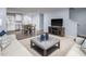 Bright and airy living space featuring modern furnishings, hardwood floors, and an open layout to the kitchen at 231 N Coral Bells Way, Four Oaks, NC 27524