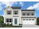 Two-story home featuring a front-facing two-car garage, a teal front door, and a well-manicured lawn at 231 N Coral Bells Way, Four Oaks, NC 27524