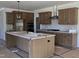 Spacious kitchen featuring dark wood cabinetry, an island, and stainless steel hood vent at 25 Bold Dr, Youngsville, NC 27596