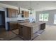 A kitchen featuring dark wood cabinetry, an island, and a stainless steel hood at 25 Bold Dr, Youngsville, NC 27596