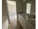 Bathroom showcases a double vanity with granite counters, with a glimpse into the connecting bedroom at 26 Harvest Hills Ln, Dunn, NC 28334