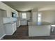 Bright kitchen features white cabinetry, granite counters, stainless appliances, and a spacious center island at 26 Harvest Hills Ln, Dunn, NC 28334