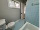 Charming bathroom with blue tile and a window allowing natural light to brighten the space at 2616 Firelight Rd, Raleigh, NC 27610