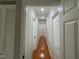 Hallway featuring multiple doors and laminate floors with overhead lighting at 2616 Firelight Rd, Raleigh, NC 27610
