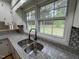 Close-up of a kitchen sink featuring granite countertops, updated faucet, and bright natural light at 2616 Firelight Rd, Raleigh, NC 27610