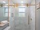 The remodeled shower has glass doors, gold accents, and a window bringing in natural light at 2706 Mcneil St St, Raleigh, NC 27608