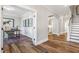 Inviting hallway showcasing hardwood floors, arched doorways, and access to an office with custom wall paneling at 307 Augusta Pond Way # 167, Raleigh, NC 27603