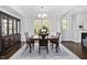 Formal dining room with coffered ceiling, modern chandelier and dark wood furniture at 3108 Bluff Oak Dr, Cary, NC 27519