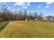 Spacious backyard featuring well-maintained lawn, mature trees, and a storage shed, perfect for outdoor activities at 36 Deep Woods Ln, Cameron, NC 28326