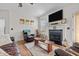 Cozy living room with a fireplace, mounted TV, and comfortable leather seating at 36 Deep Woods Ln, Cameron, NC 28326