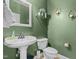 Elegant powder room featuring a pedestal sink, lovely green walls and decorative sconces at 36 Deep Woods Ln, Cameron, NC 28326