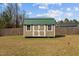 Close up view of the backyard storage shed featuring a light green roof and double doors at 36 Deep Woods Ln, Cameron, NC 28326