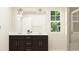 Well-lit bathroom with a dual sink vanity, modern fixtures, and a glass-enclosed shower at 4012 Shadbush St, Raleigh, NC 27616