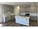 Open kitchen features gray cabinets, an island with a sink, white subway tile, and stainless steel appliances at 4012 Shadbush St, Raleigh, NC 27616