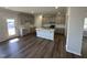 Bright kitchen features gray cabinets, an island with sink, white subway tile backsplash, and stainless appliances at 4012 Shadbush St, Raleigh, NC 27616