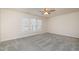 Bright bedroom featuring neutral carpet, ceiling fan, and three sunny windows at 4220 Congleton Pl, Durham, NC 27703
