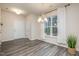 Inviting dining area with a modern chandelier, large windows, and elegant gray wood floors at 4220 Congleton Pl, Durham, NC 27703