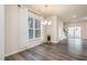 Bright dining area featuring a modern chandelier, large windows, and stylish gray wood flooring at 4220 Congleton Pl, Durham, NC 27703