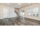 Bright living area with sliding glass doors to a patio, staircase, and stylish gray wood flooring at 4220 Congleton Pl, Durham, NC 27703