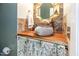 Rustic-style bathroom featuring a unique stone vessel sink, wooden countertop, and decorative mirror at 4516 Ocean Crest Cir, Raleigh, NC 27603