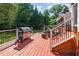 View of an outdoor deck with a stainless steel grill and wooded backyard at 4516 Ocean Crest Cir, Raleigh, NC 27603