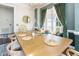 Light and airy dining room featuring a wooden table and chairs, large windows with green curtains at 4516 Ocean Crest Cir, Raleigh, NC 27603