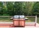 Stainless steel grill on an exterior deck with railings and wooded backyard at 4516 Ocean Crest Cir, Raleigh, NC 27603