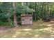 A backyard shed with double doors, nestled among mature trees on a well-maintained lawn, providing outdoor storage at 4516 Ocean Crest Cir, Raleigh, NC 27603