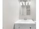 A well-lit bathroom vanity features modern white cabinetry and a large, bright mirror at 4911 Hollenden Dr # 208, Raleigh, NC 27616