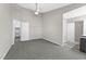 Neutral bedroom features ceiling fan, carpeting, and view into adjacent kitchen at 4911 Hollenden Dr # 208, Raleigh, NC 27616