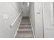 Carpeted staircase leading to the upper level, complemented by white walls and a convenient storage closet at 4911 Hollenden Dr # 208, Raleigh, NC 27616