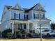 Charming two-story home featuring a welcoming front porch, a well-manicured lawn and attached garage at 505 Ivy Arbor Way, Holly Springs, NC 27540