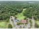 Stunning aerial view of a golf course, clubhouse, and surrounding treescapes at 5125 Salinas Ct, Holly Springs, NC 27540
