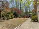 Expansive backyard featuring lush landscaping, a brick patio, and a cozy fire pit area, perfect for outdoor relaxation at 5125 Salinas Ct, Holly Springs, NC 27540
