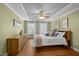 Comfortable bedroom with hardwood floors, light green walls, and a ceiling fan at 5125 Salinas Ct, Holly Springs, NC 27540